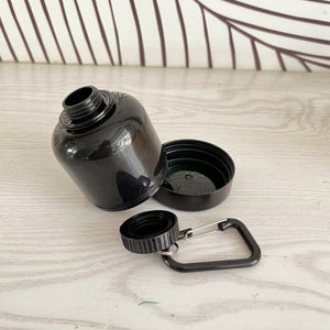 Black water bottle with carabiner on a light wooden surface