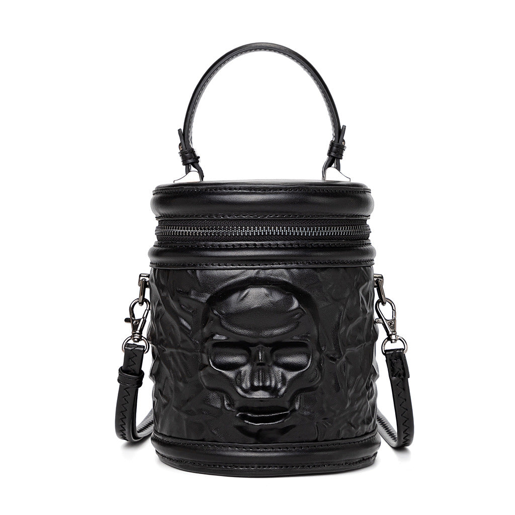 738400181-2 - Black cylindrical Halloween handbag with an embossed skull, zip-around lid, top handle and detachable shoulder strap.
