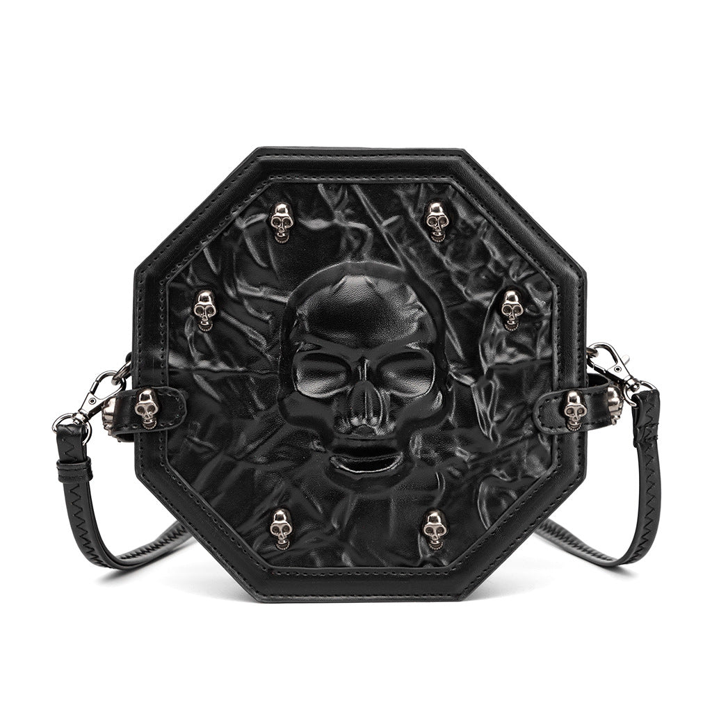989128052-4 - Octagonal black Halloween crossbody bag with a large embossed skull, textured front and small silver-tone skull studs.
