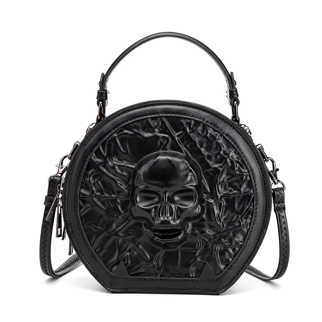 167243085-1 - Round black Halloween crossbody bag with an embossed skull, textured front, top handle and clip-on shoulder strap.
